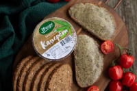 Uz koka dēlīša sagriezta maize un sviesta trauciņš